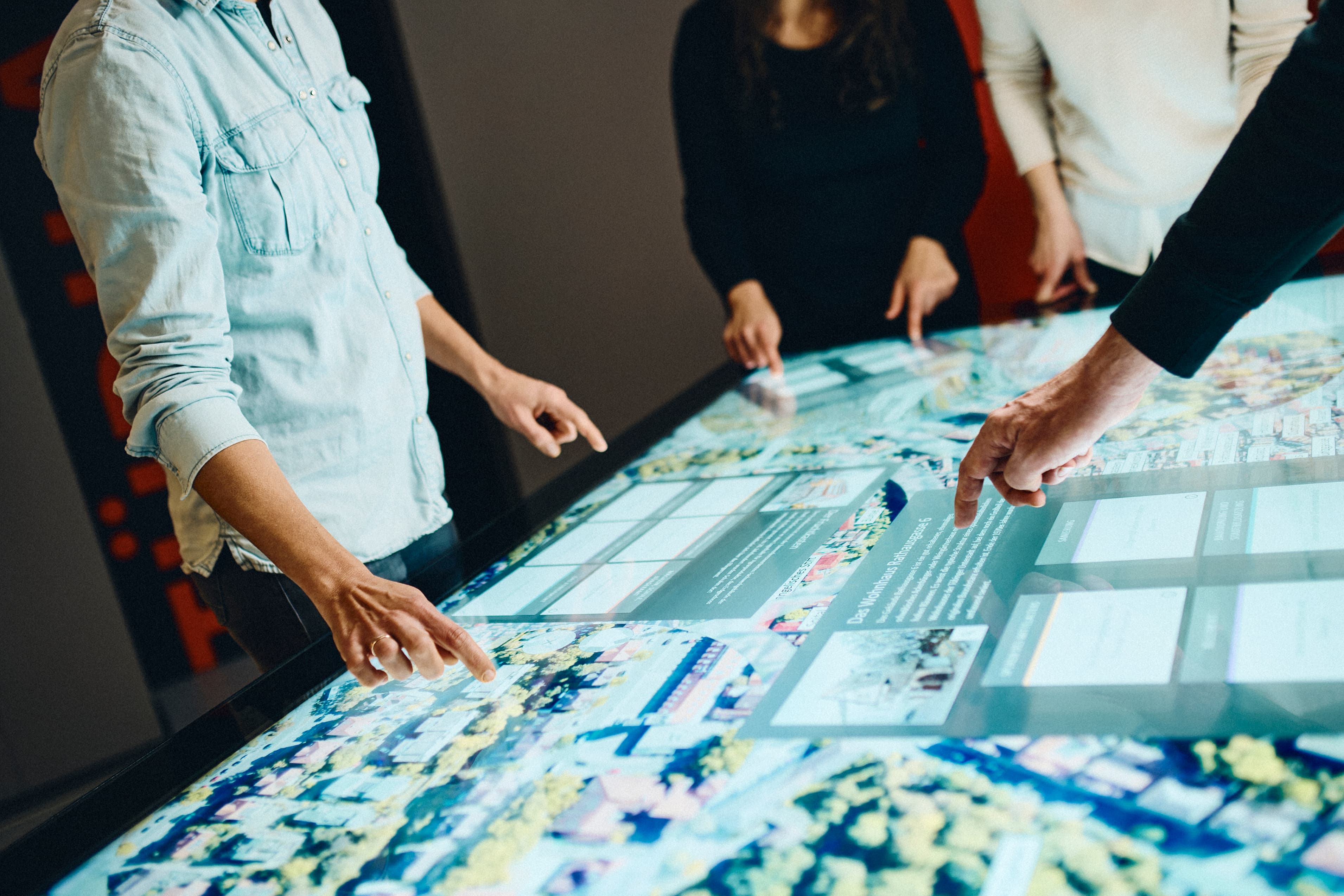 Mehrere Personen arbeiten gemeinsam an einem Multi-Touch-Tisch