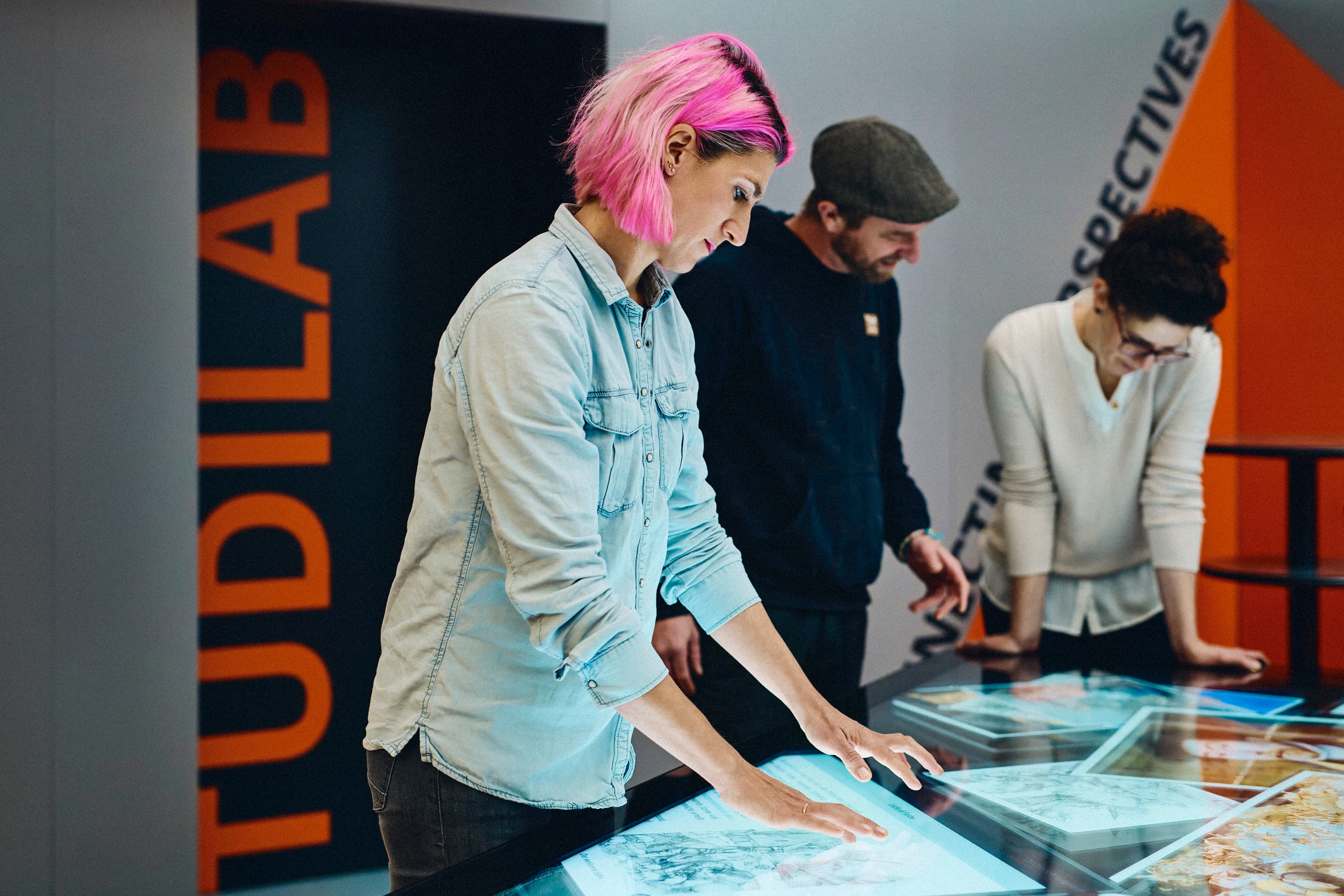 Mehrere Personen bedienen einen Multi-Touch-Tisch vor dem TüDiLab