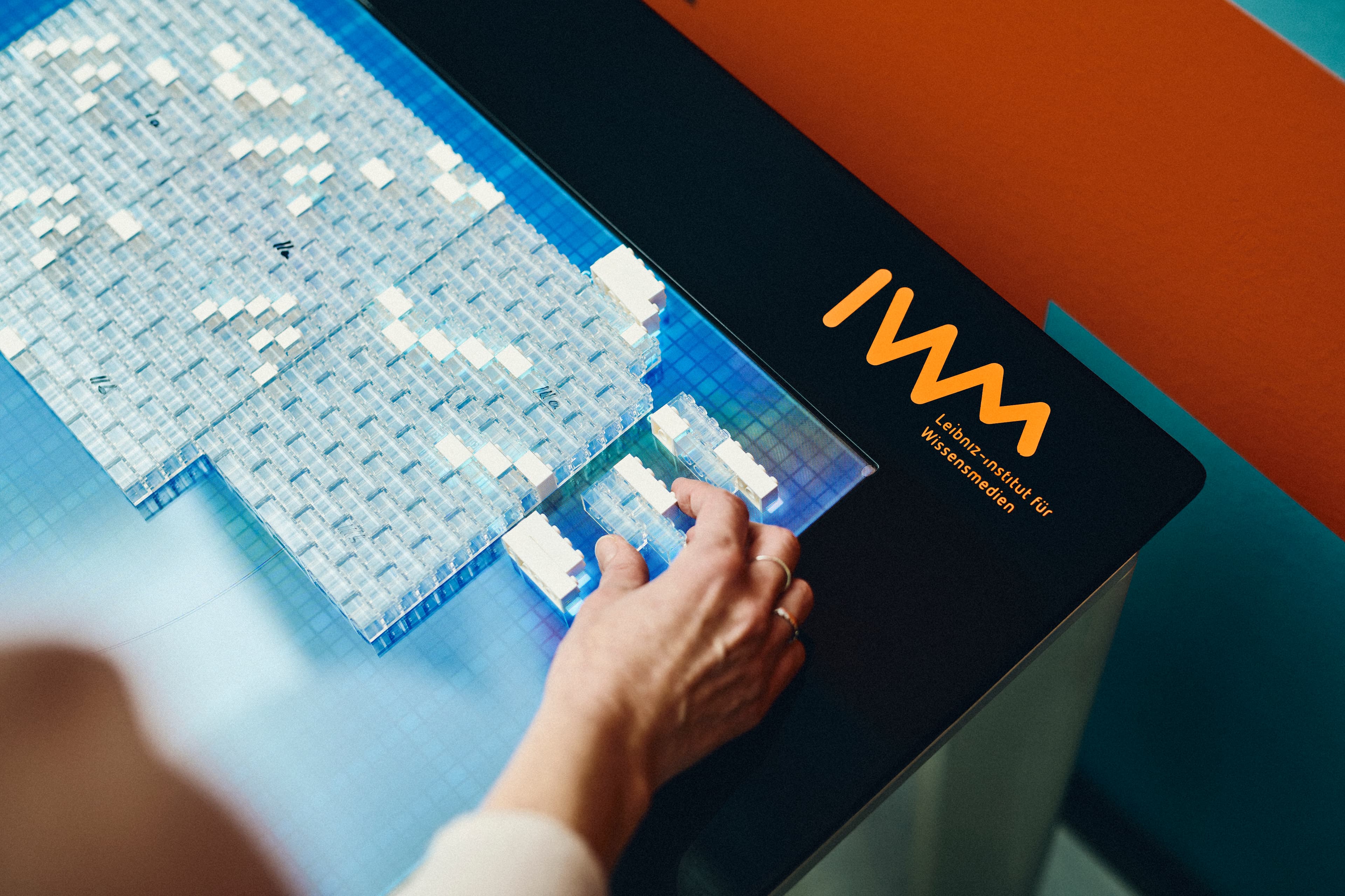 Eine Person bedient den LEGO-Tisch im IWM