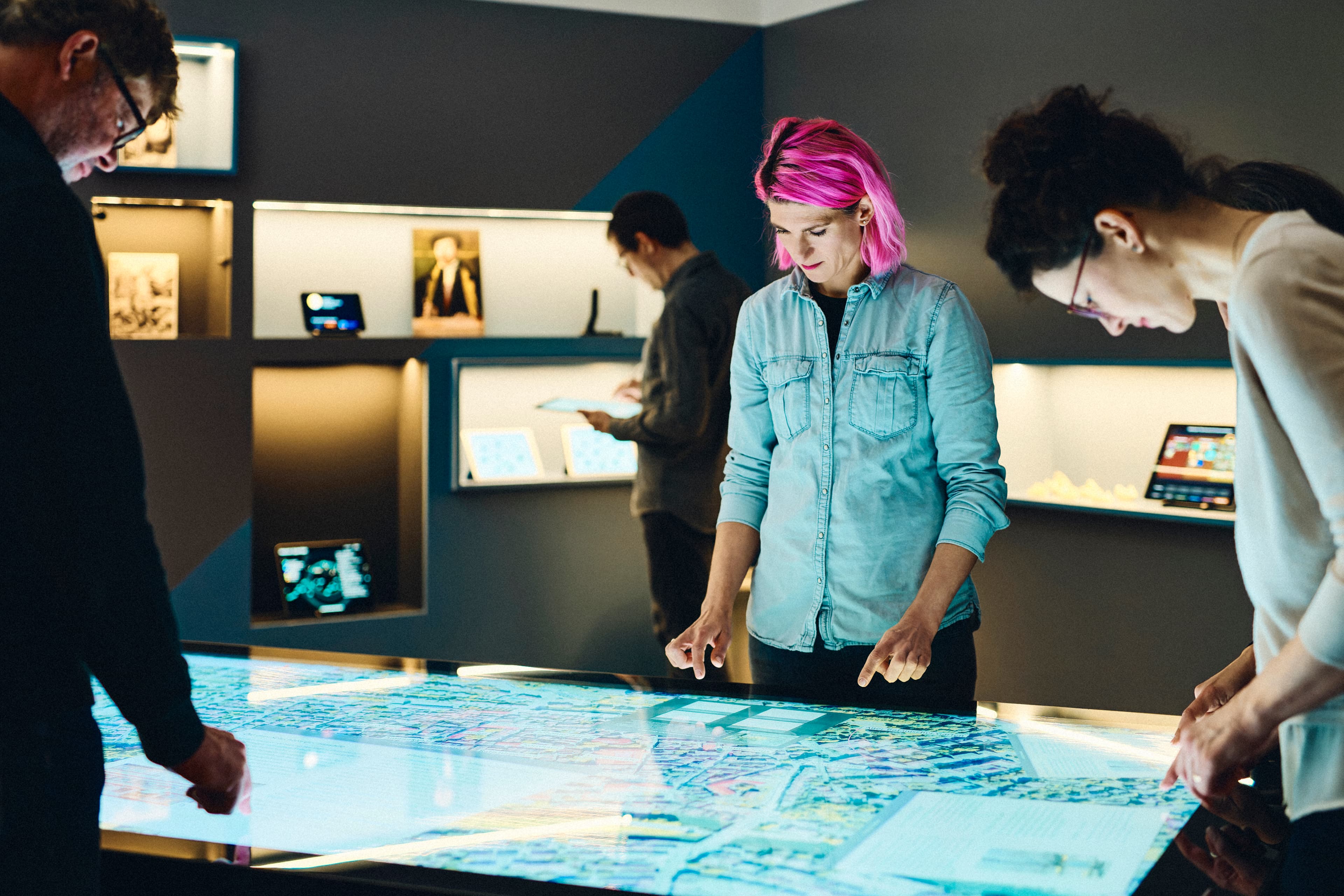 Mehrere Personen arbeiten gemeinsam an einem Multi-Touch-Tisch im IWM
